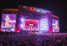 Nighttime outdoor concert with a huge illuminated stage and a dense crowd watching a performance.